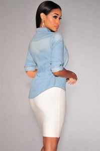 Detail of light wash denim shirt featuring classic collar, chest pockets and adjustable cuffs