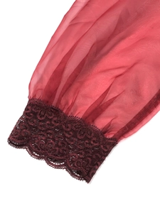Detail of red sheer mesh sleeve with intricate lace trim and romantic floral embroidery