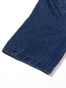 Dettaglio della manica in denim blu scuro con doppie cuciture piatte di qualità