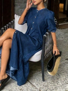 Détail d'une robe en jean bleu foncé avec manches bouffantes et boutonnage sur mannequin