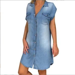 Detail of light blue sleeveless denim shirt dress with flap pockets and metal buttons
