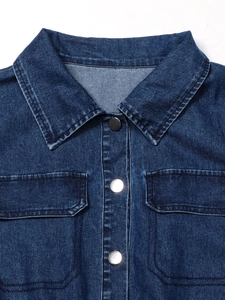 Dettaglio di abito in denim blu scuro con bottoni in metallo e tasche con patta rifinite