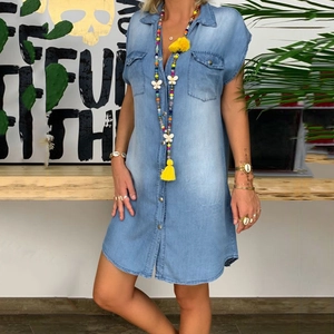 Detail of light blue short sleeve denim shirt dress with lapel collar and flap pockets
