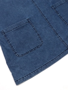 Detailed view of dark blue denim dress featuring symmetric pockets and double-needle stitching