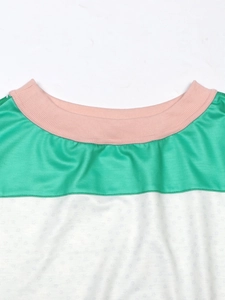 Detailed close-up showing pink ribbed neckline and green patchwork on striped floral sweatshirt