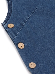 Detailed view of blue washed denim dress featuring three vintage round wooden buttons