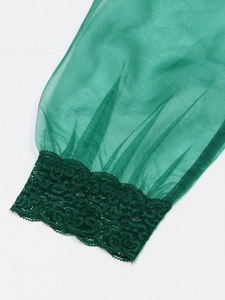 Detailed macro view of green mesh puff sleeve cuff with intricate floral lace trim accents