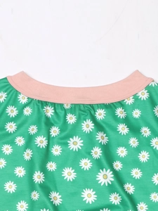 Close-up of pink ribbed neckline and white daisy print on green striped floral tee