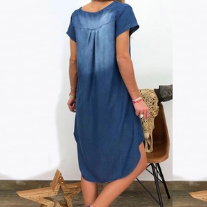 Rear view of washed denim dress featuring distressed back and curved asymmetric hemline