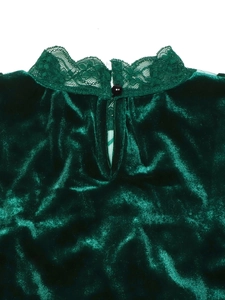 Close-up of lace collar with button and teardrop cutout on dark green velvet top