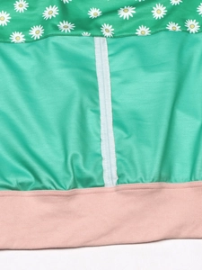 Detail of floral print sweatshirt showing green daisy pattern and mint green stitched seams