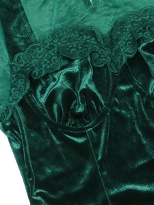 Detail of dark green velvet fabric with intricate lace trim and pleated chest design