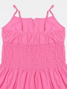 Dettaglio del bustino elastico a punto smock su abito estivo rosa con spalline