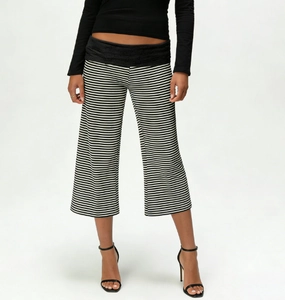 Detail view of high-waisted black and white striped wide-leg trousers with elastic waistband
