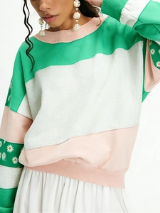 Close-up of striped sweatshirt featuring colorful stitching and white daisy prints