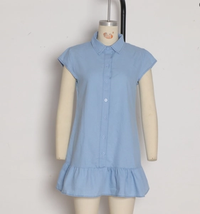 Détail d'une robe chemise bleu clair avec boutonnage et ourlet à volants étagés