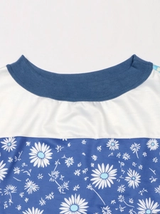 Detail view of the blue ribbed crew neck and white fabric with daisy flower print