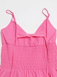 Dettaglio di un vestito rosa con corpetto a punto smock elastico e spalline sottili