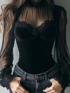 Detail of high neck lace trim and sheer mesh sleeves on black velvet slim-fit top