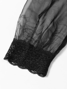 Detailed view of sheer black organza sleeves with intricate lace trim on the cuff