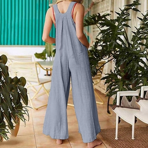 Detail of loose fit light blue cotton linen overalls with side pockets and back view