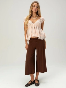 Women's pink lace ruffled top and brown wide-leg shorts in a bohemian casual style