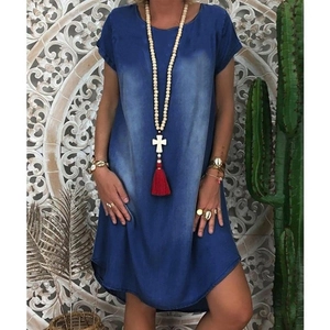 Detail of loose fit denim dress featuring washed blue fabric and bohemian necklace