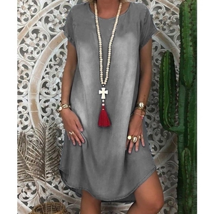 Detail of loose gray washed denim dress showing the round neck and curved split hem