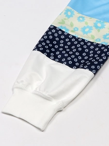 Close-up of ribbed cuffs with colorful patchwork stripes and daisy flower patterns