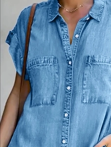 Close-up of light blue denim short sleeve dress with lapel collar and chest pockets