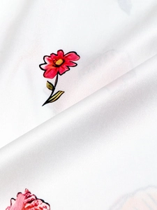 Dettaglio della stampa floreale rossa su abito in raso bianco con trama liscia
