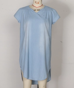 Detail of light blue denim dress showing V-neckline and curved high-low split hemline