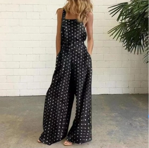 Détails de la combinaison noire à pois avec boutons latéraux et coupe jambe large