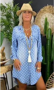 Detail view of light blue denim shirt dress featuring white star prints and pocket details
