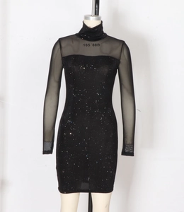 Détail du col montant avec manches en mesh et tissu à paillettes sur robe noire