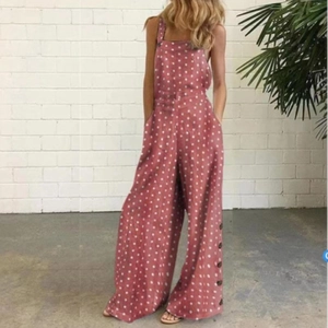 Détail de la salopette rose à pois avec jambe large et boutons sur les côtés