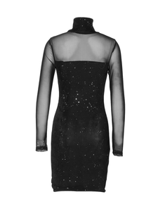 Détail de la robe moulante noire avec paillettes argentées et manches en tulle