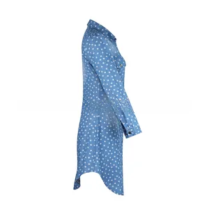 Detail of light blue denim shirt dress featuring white star pattern and curved hem