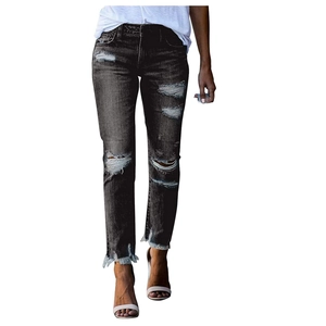 Détails du jean avec déchirures aux genoux et bords effilochés en gris foncé délavé