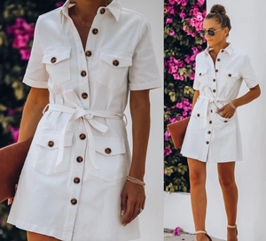 Detail of white cargo dress featuring notched lapel and tortoiseshell buttons closure