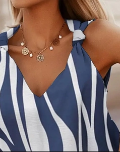 Detail of blue zebra print sleeveless top featuring V-neckline and shoulder tie knots