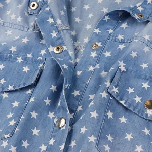 Detail view of denim dress collar with white star print and silver metal buttons