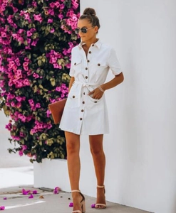 Detailed view of white short-sleeved button-down shirt dress with waist tie and pockets