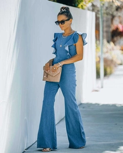 Detail of light blue denim jumpsuit featuring ruffle sleeves and flared leg design
