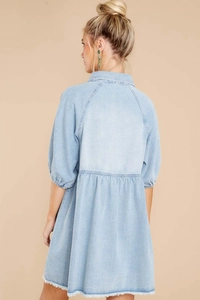Detailansicht des ausgefransten Saums an einem hellblauen Jeanskleid mit Puffärmeln