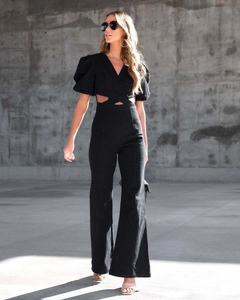 Detail of black jumpsuit with waist cut-outs, puff sleeves and wide leg design