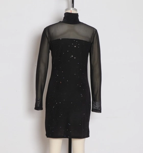 Détail d'une robe de cocktail noire avec manches en mesh et tissu à paillettes scintillant
