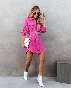Detail of hot pink corduroy shirt dress featuring chest pockets and matching waist belt