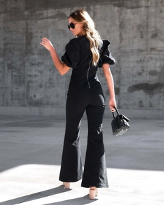 Close-up of black denim jumpsuit featuring puff sleeves and a sleek back metal zipper