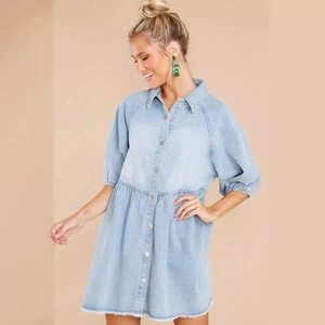 Hellblaues Jeans-Hemdkleid mit Puffärmeln und ausgefranstem Saum auf beigem Grund